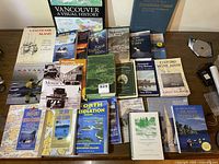 Photo showing a full spread of coastal exploration and history books arranged on a table, including titles on Vancouver Island, kayaking, and boating.