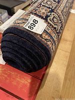 Rug rolled with lot tag visible