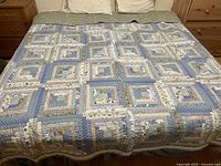 Full view of quilt laid on king bed showing overall log cabin design and size