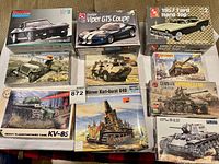 Photo showing a collection of various car and military model kits, including Monogram Dodge Charger, AMT 1957 Ford Hard Top, Dodge Viper GTS Coupe, and multiple military vehicles.