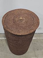 Full view of round woven basket with lid closed to show shape and woven texture.