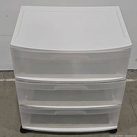 Front view of white plastic storage cabinet with closed drawers.