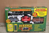 Front box packaging showing train set components visible, including the locomotive, coal tender, and caboose in a sealed box.