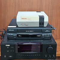 KLH R3100 stereo receiver, Emerson EV506N VCR, Nintendo Entertainment System console stacked for display