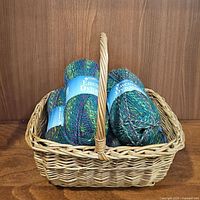 Five bundles of yarn labelled Encore Dynamo arranged inside a woven basket
