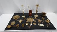 Full collection of brass items arranged on black cloth.