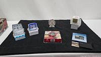 Overview of all clocks and items laid out on black cloth