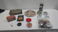 Table with assorted tins, molds, small cutters, kitchen tools including cheese grater and glass molds