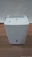 Front view of the white GE dehumidifier showing air vent and water level indicator on front panel.