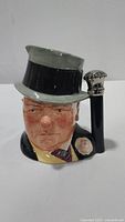 Full frontal photo showing the character vase with a top hat and cane handle