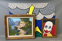 Three framed oil paintings arranged together showing a landscape, clown portrait, and colorful background artwork.