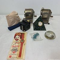 Full lot of vintage pencil sharpeners, watch, camera, clock, Gumby toy, and decorative items