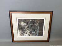 Framed leopard photograph displayed on a grey wall, showing the full artwork and frame
