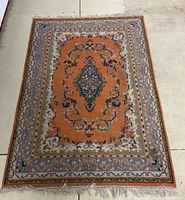 Full view of the oriental area rug on concrete floor, showing overall design and color.