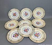 Set of 9 ornate Rosenthal Selb Germany porcelain dinner plates arranged in a circular pattern, showing floral bouquet in center and gold borders.