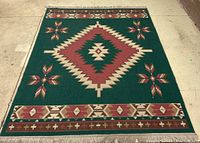 Full view of the rectangular area rug showing geometric patterns and fringes