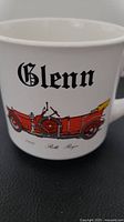 Side view of white mug showing red 1910 Rolls Royce illustration and black Gothic font name 'Glenn'