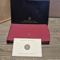 Outer black sleeve and burgundy presentation case with specification card visible