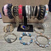 Overview of bracelets on stand and additional pieces on table