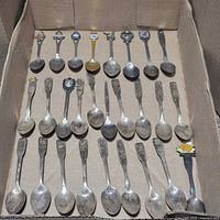 Box containing three rows of 24 Canadian souvenir spoons