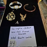 All five jewelry pieces arranged on black board