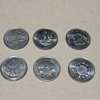 Six coins reverse side visible with assorted commemorative designs