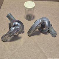 Two chrome lever handles and screw vial overview