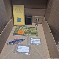 All items laid in box: booklets, dime dispenser, handbook, coin bags, emblem