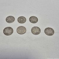 Seven Canadian 25-cent coins laid out
