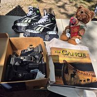 Overall lot showing skates, book, bear, and box of brackets