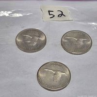 Three 1967 Canada Centennial silver dollar coins arranged on flat surface