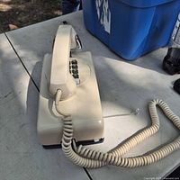 Side view showing telephone base, handset and coiled cord
