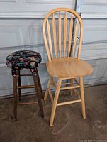 Two bar stools side by side showing differences in style and finish, in front of a garage door on a concrete floor.
