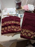 Full view of assorted bathroom towels, fingertip towels and tissue holder with decorative edge towels in the foreground