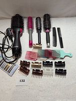 Full lot showing all hair styling tools and accessories arranged on a flat white surface, including an electric hair dryer, four round brushes, two combs, and multiple hair clips.