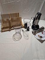 Cuisinart hand blender with attachments including whisk, chopper, mixing cup, and instructions on white background.