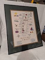 Angled view of framed cross-stitch map showing details of artwork and frame