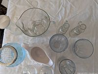 Top view of set of miscellaneous glassware, including pitcher, bottles, glasses and gravy boat