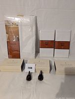 Full lot showing packaged white tablecloth, 8 napkins wrapped with brown "French Table" bands, and 3 boxes of brown bird-shaped place card holders with two holders displayed.