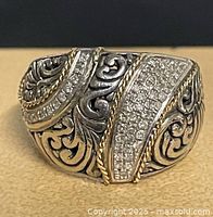 Front view of ring showing scrollwork and diamond pavé.