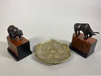 Photo showing the Zodiac disc centered between the Wall Street bull and bear bookends on wooden bases.