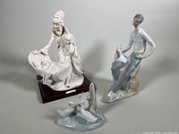 Photo showing the three porcelain figurines together: mother/daughter with cradle, boy with dog, and geese in pond.