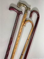 Four walking sticks/canes laid flat showing full length and styles