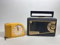 Photo showing both the yellow Westclox Moonbeam alarm clock and black Motorola Roto-Tenna tube radio side by side, highlighting their vintage condition and size comparison