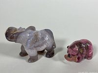Front and side view of agate elephant and rhodonite bear holding fish, showing color, size, and details.