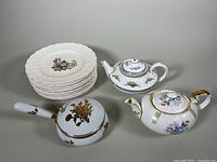 Four 9 inch Spode white porcelain plates stacked, a Royal Doulton teapot, and a porcelain butler crumb catcher with floral designs and gold accents