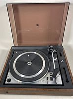 Full view of DUAL 1228 turntable with lid open, showing platter, tonearm, controls and wood housing.