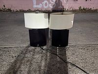 Two matching night lamps placed next to each other with visible black rectangular bases and off-white rounded shades.
