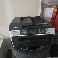 Front view of Brother MFC-6490CW printer showing control panel, numeric keypad, and paper trays.
