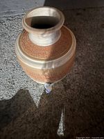 Top angled view showing wide mouth opening and embossed pattern on body with attached spigot